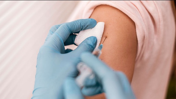 Verabreichung einer Impfung in den Oberarm eines Patienten.