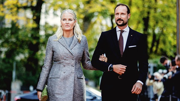 Kronprinz Haakon von Norwegen, und Kronprinzessin Mette-Marit von Norwegen laufen in Berlin unter Bäumen, Arm in Arm
