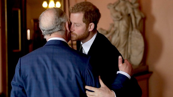 Prinz Harry  begrüßt seinen Vater, Prinz Charles, mit einem Kuss auf die Wange. 2018