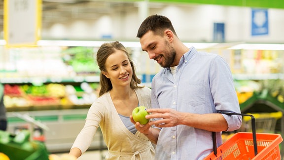 ein junges Paar beim einkaufen in der Obst- und Gemüseabteilung eines Supermarktes