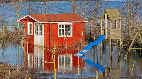 Gartenhaus und Spielgeräte stehen im Hochwasser