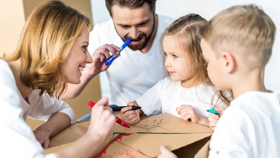 Eine Familie mit 2 Kindern malen zusammen