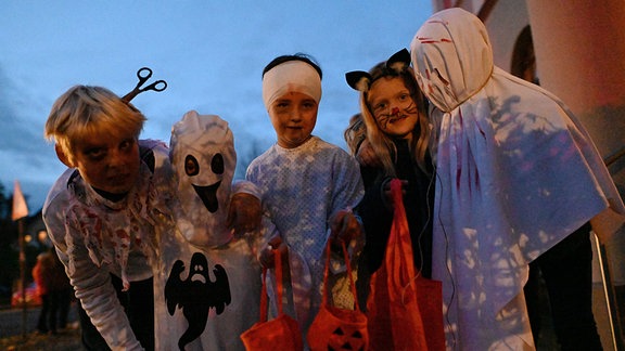 Kostümierte Kinder mit Taschen für Süßigkeiten