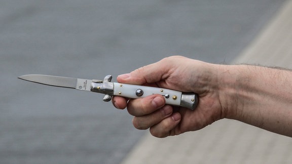 Eine Person hält ein Messer.