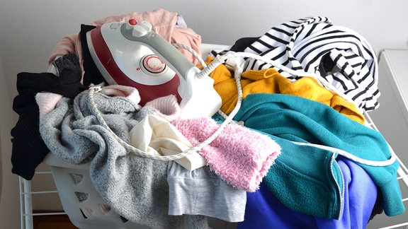 Wäsche und ein Bügeleisen in einem Wäschekorb