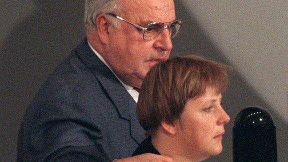Der CDU-Vorsitzende, Bundeskanzler Helmut Kohl, legt während des CDU-Parteitags am 28. November 1994 in Bonn den Arm um seine Stellvertreterin Angela Merkel