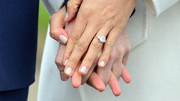 Die Hand des britischen Prinzen Harry (l) und die Hand der US-amerikanischen Schauspielerin Meghan Markle (r).