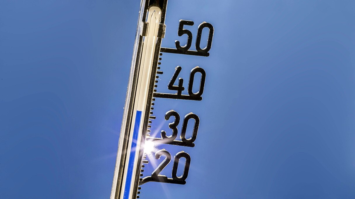 Thermometer vor wolkenlosen Himmel zeigt 7°C