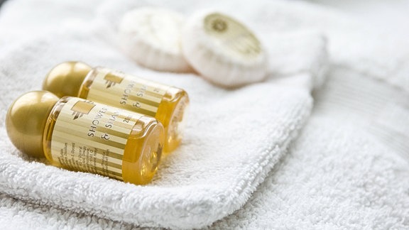 Handtuch, Waschlappen, Shampoo und Seife in einem Hotelzimmer