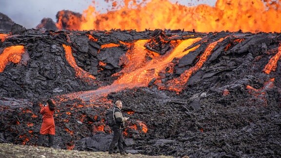 Menschen schauen 2022 auf den Lavafluss des Vulkans Fagradalsfjall.