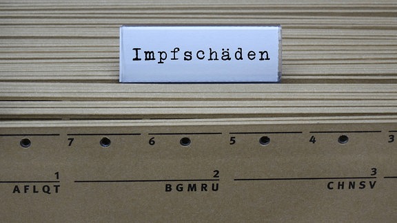 An einem Hängeregister steht der Schriftzug Impfschäden.