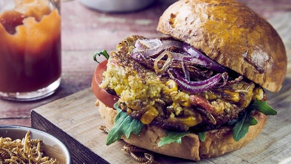 Frisch zubereiteter Insektenburger mit frittierten Mehlwürmern.