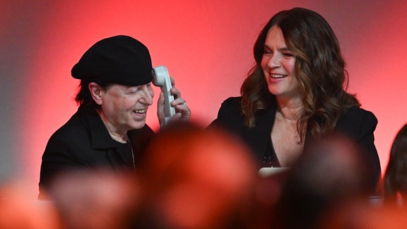 Eiskunstlauf Olympiasiegerin Katarina Witt und der Sänger und Frontmann der Scorpions, Klaus Meine, sitzen am Spendentelefon auf der Bühne der 30. José Carreras Gala. 