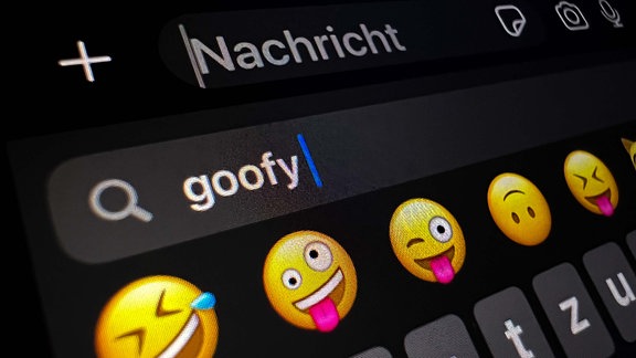 Im Display eines Smartphones ist im Suchfeld für Smileys das Wort «goofy» (komisch, tollpatschig) zu lesen.