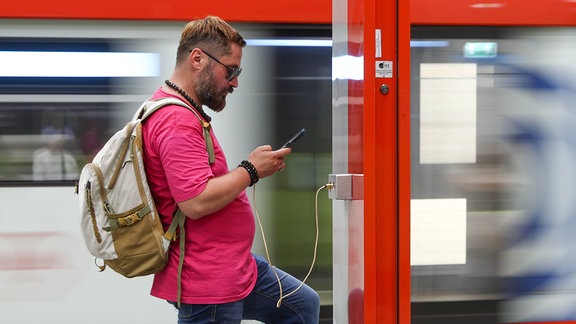 Ein Mann lädt ein Mobiltelefon in einer Moskauer U-Bahn-Station auf.