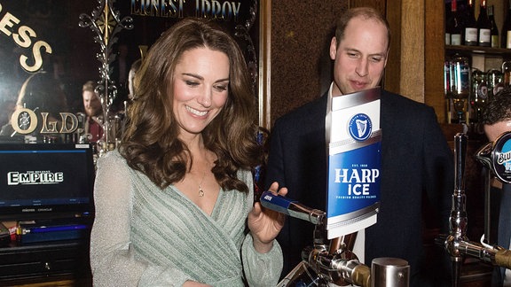 Catherine, Herzogin von Cambridge, zapft ein Pint Bier, während Prinz William, Herzog von Cambridge, bei einem Besuch der Empire Music Hall Belfast am 27. Februar 2019 in Belfast, Nordirland, zusieht.