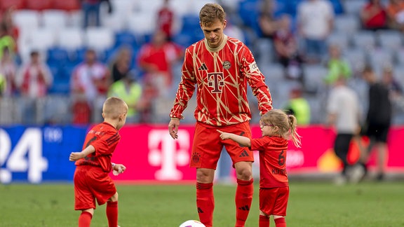 Joshua Kimmich (FC Bayern München) mit seinen Kindern auf dem Platz