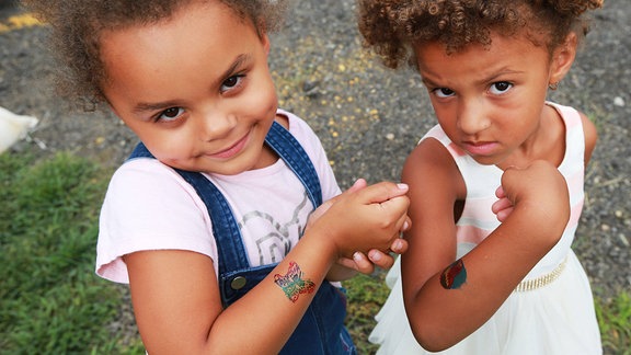 Zwei Mädchen zeigen ihre Kindertattoos