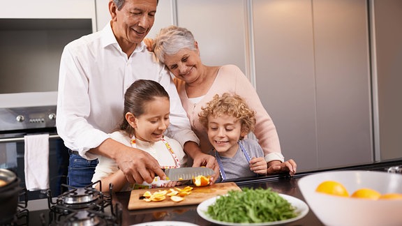 Großeltern kochen mit ihren Enkelkindern