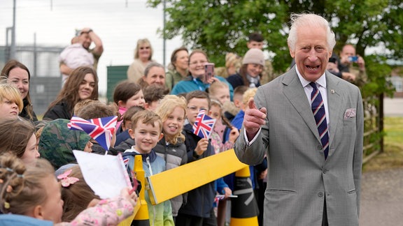 König Charles geht an einer Gruppe Kinder vorbei.