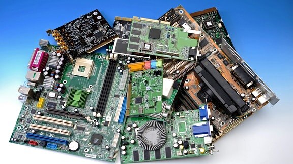 Verschiedene Computerplatinen liegen auf einem Haufen.