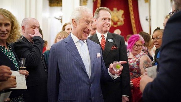 Der britische König Charles III. spricht während eines Empfangs im Buckingham Palace zu den Gästen.