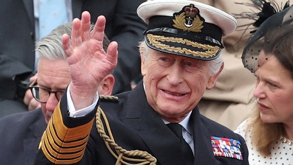 König Charles III. winkt vor der Militärprozession anlässlich des 80. Jahrestages des Victory Europe Day.