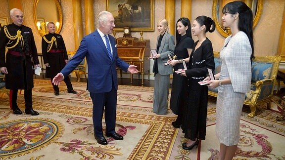 Britain's King Charles III, left. presents the members of the K-Pop band Blackpink