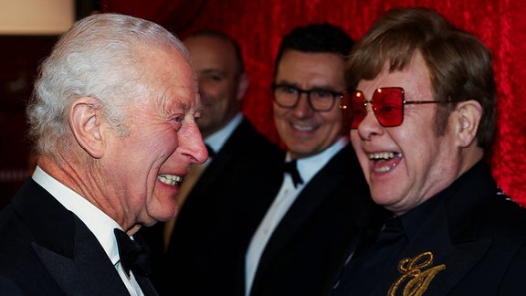 König Charles lacht mit Elton John bei der Royal Variety Performance in London 2024. 