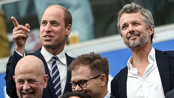Dänemarks König Frederik X. (r) und William, Prinz von Wales, vor Spielbeginn auf der Tribüne.