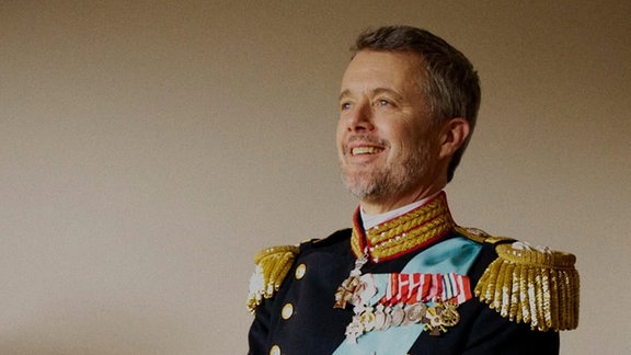 König Frederik in Uniform lächelt.