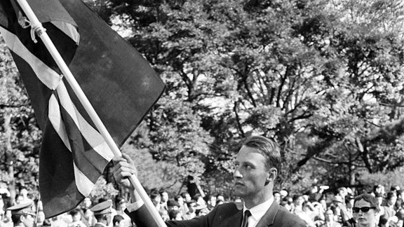 Kronprinz Harald als Fahnenträger der Norwegischen Mannschaft bei den Olympischen Sommerspielen 1964 in Tokyo.