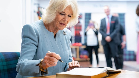 Königing Camilla schreibt in ein Buch