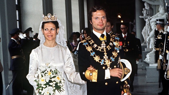 König Carl XVI. Gustaf von Schweden und seine Braut Silvia wandeln nach der Trauung am 19.6.1976 in Stockholm durch den Schlosshof.