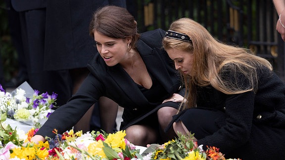 Prinzessin Eugenie und Prinz Beatrice betrachten nach dem Tod von Queen Elizabeth die Blumen vor dem Balmoral Castle in Schottland.