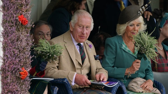 König Charles III. und Königin Camilla verfolgen die Braemar Highland Games.