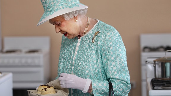 Queen Elizabeth II mit einem Gebäck