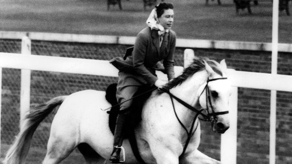 Queen Elizabeth II. reitet am 16.06.1961 auf der Rennstrecke von Ascot am letzten Tag des berühmten "Royal Ascot"- Pferderennens während eines spontanen Rennens.