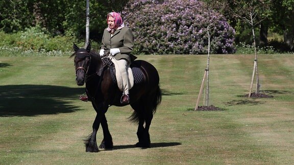 Queen Elizabeth II reitet auf einem Pferd.