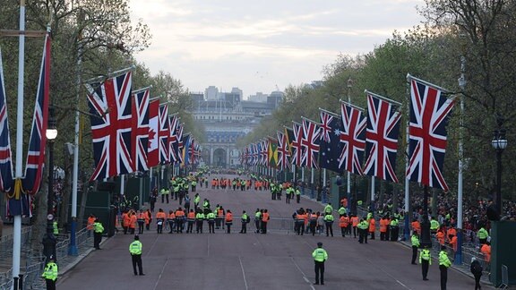 Viele Polizisten in abgesperrter Allee, die mit britischen Flaggen dekoriert ist