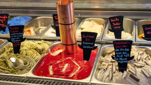 In einerer Eistheke befindet sich die Sorte "Konklave-Eis" mit einem kleinen Schornstein mit Weihrauch und einer ins Eis gemalten Tiara.