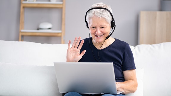 Frau nimmt an Online Video Konferenz teil