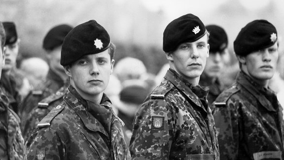 Schwarz-Weiß Foto von Soldaten, die in einer Reihe stehen.