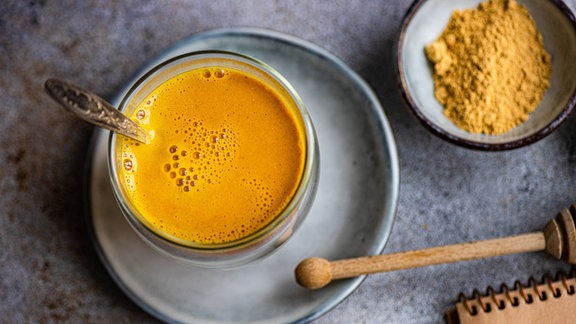 Das Gewürz Kurkuma und eine Tasse Goldene Milch (Golden Milk).