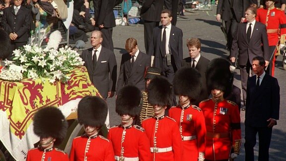 Zwischen seinem Großvater Prinz Philip (l) und seinem Onkel, Charles Graf Spencer (2.v.r), folgt Prinz William am 06.09.1997 in London mit gesenktem Kopf dem Sarg seiner Mutter, Prinzessin Diana.