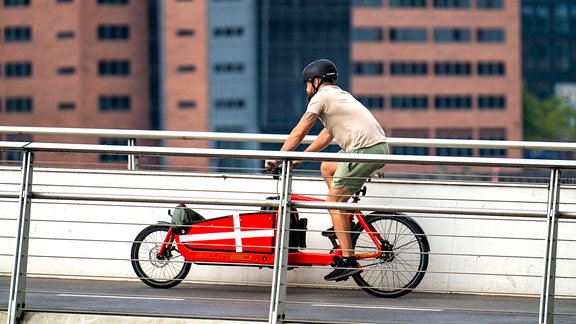 Ein Mann fährt mit einem Lastenrad