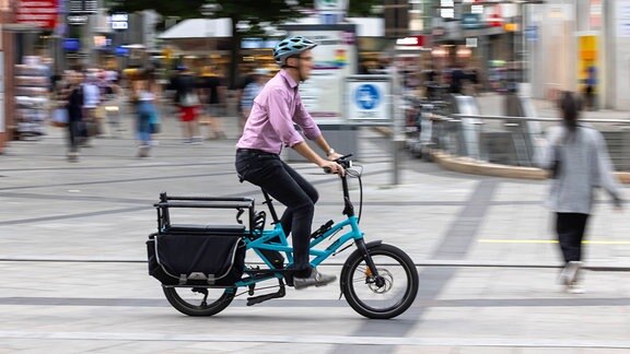 Ein Mann fährt mit einem Lastenrad
