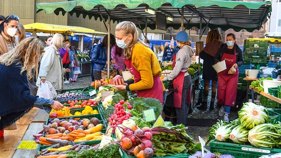 Gemüse auf einem Wochenmarkt liegt in Kisten an einem Stand.