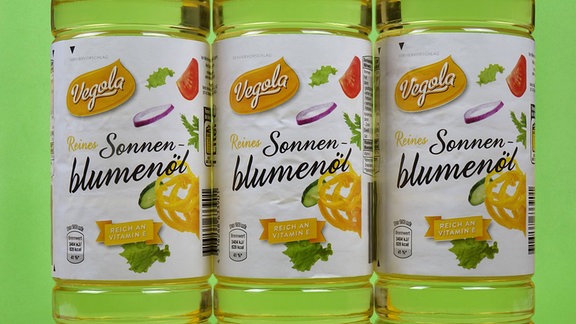 Drei Flaschen Sonnenblumenkernöl nebeneinander.