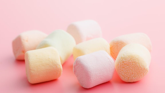 Süße Marshmallows auf rosa Hintergrund.